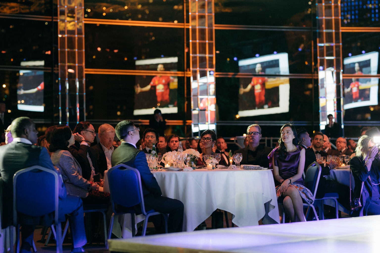 Guests seated around a candlelit gala dinner table.